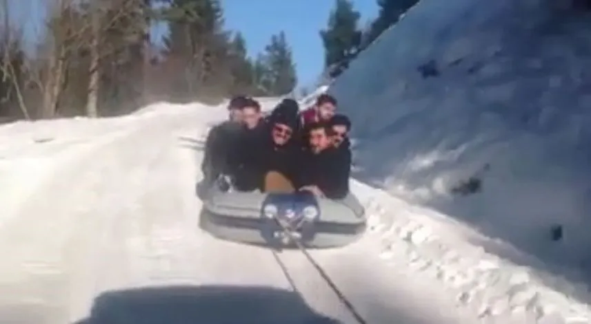 Araçlarına bağladıkları rafting botuyla kar üstünde kayarak çocuklar gibi eğlendiler